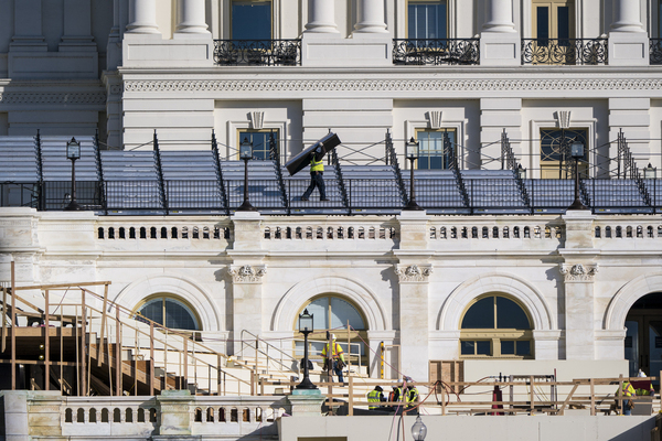 construction crews work on the platforms where the president-elect will take the oath of office, at the Capitol in Washington