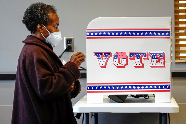 A woman cases a ballot on a voting machine in the 2020 US election.