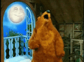 The bear from The Bear in the Big Blue House does a dance as he stands near a window with The Moon in the sky, dancing along.