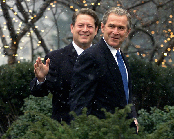 Al Gore waves as he walks with George W Bush