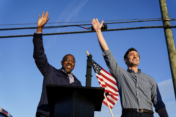 Democratic candidates Raphael Warnock and Jon Ossoff wave