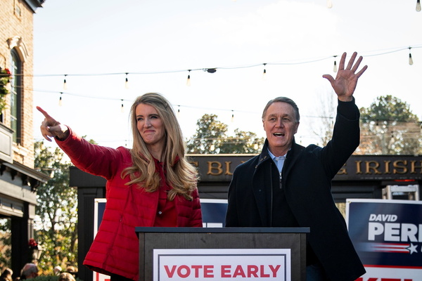 Senator Kelly Loeffler (R-GA) and Senator David Perdue (R-GA), wave during a campaign event.