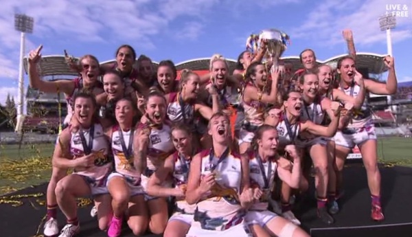 The Brisbane Lons AFLW players celebrate with the premiership trophy.