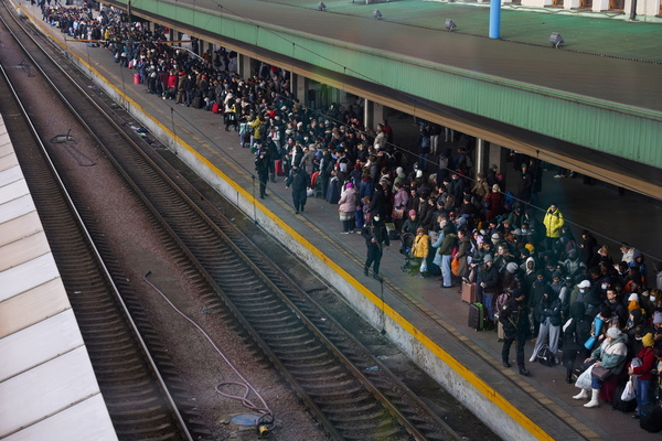 a train platform is packed with people