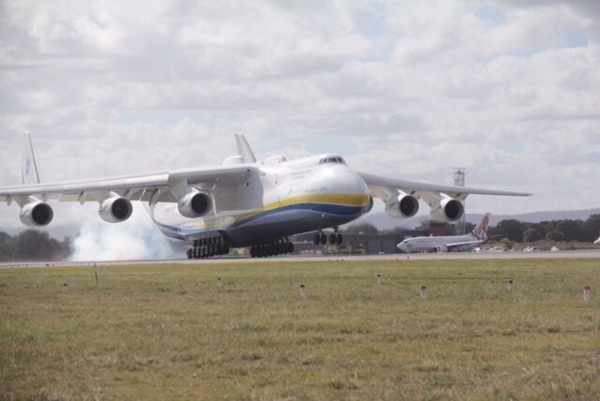 A large cargo plane with six engines lands.