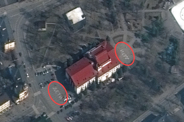 A satellite image shows a red rooved building with Russian letters on the lawns in front and behind