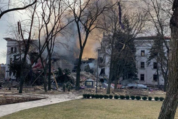 A gaping hole down the middle of a three-storey white building, smokes spewing from the damage