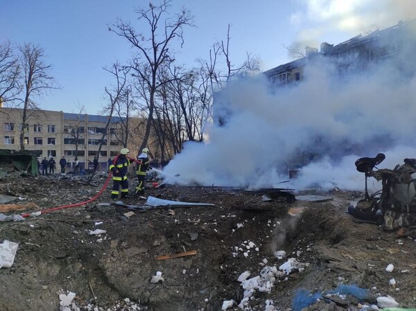 Two firefighters aim a hose at a large plume of white smoke