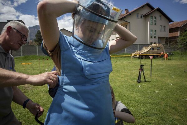 A woman dresses in blue protective clothing.